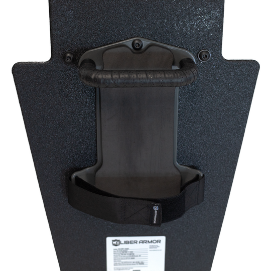 Close up of backside of black 15" x 25" Caliber Armor Pistol rated Level IIIA HG2 Ballistic Shield with handle in the center, padded arm rest & quick release strap on a white background 4