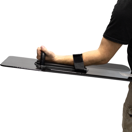 Person holding a black bullet proof shield with thier arm through the velcro retention strap & grabbing the wrapped handle on a white background 7