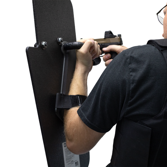 right handed officer holding a 15" x 25" Caliber Armor Rifle rated Level III+ RF2 Ballistic Shield with pivoting handle mounted for left handed use aiming through a pistol with sight  4