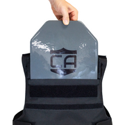 Person holding a gray armor plate showing it being top loaded into backside of patrol vest 4