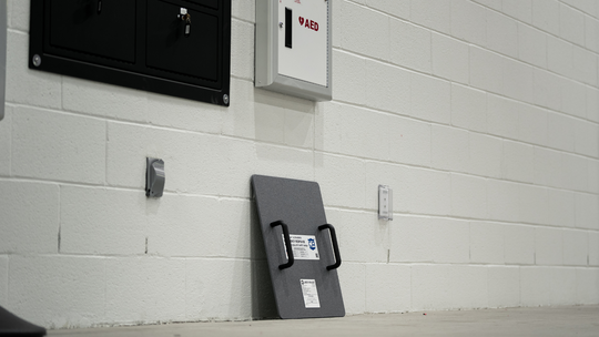 Level IIIA Ballistic shield against a white brick wall placed next to AED & other emergency response or active shooter protective gear 5